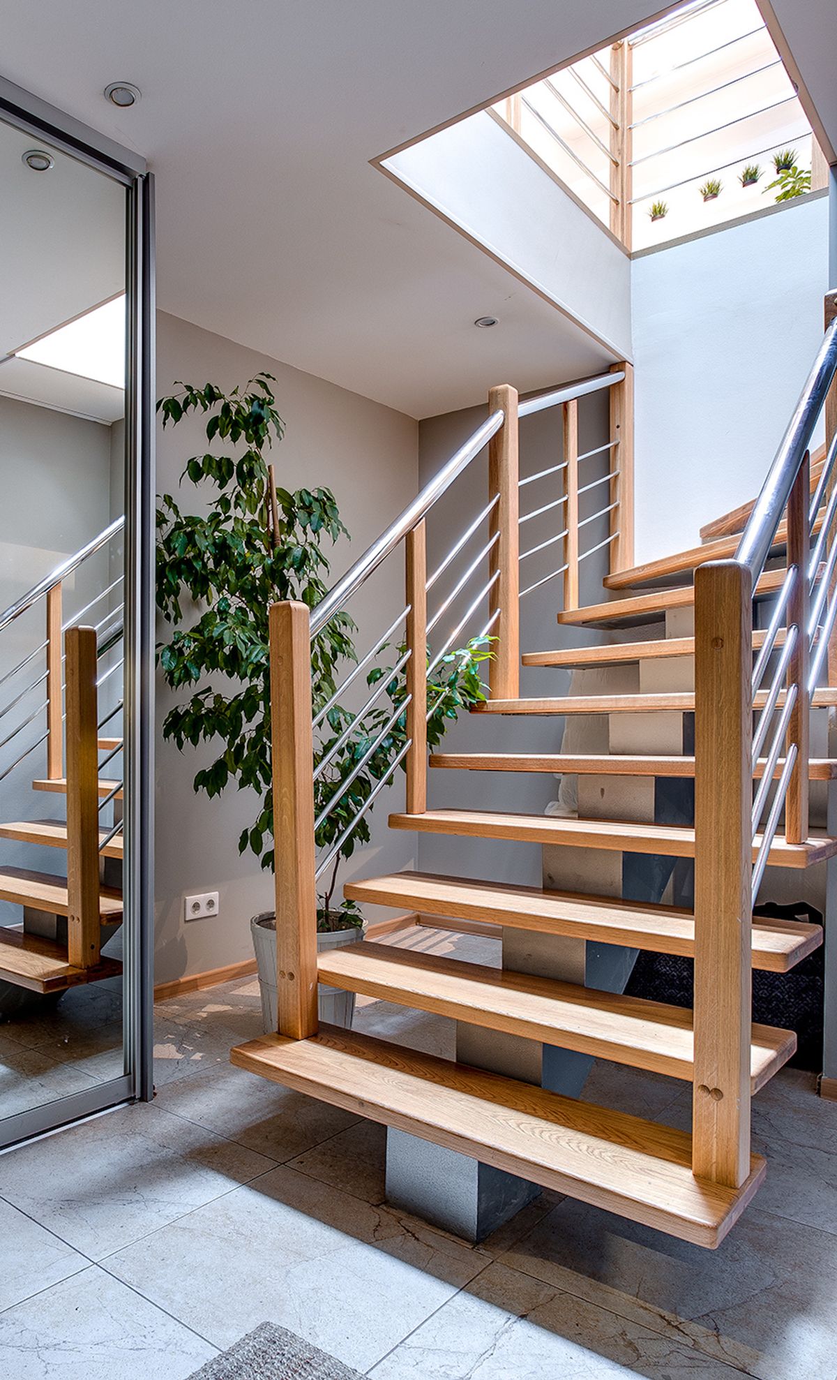 Intérieur moderne avec un escalier en bois sous une verrière
