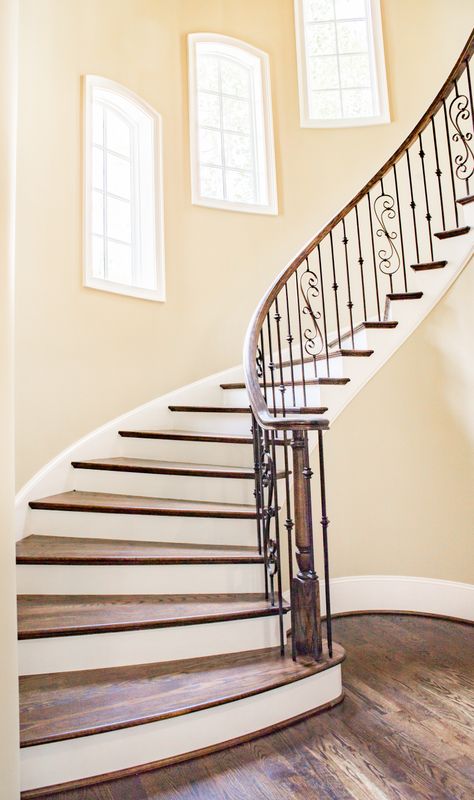 Escalier en bois avec rampe en fer forgé et lumière naturelle